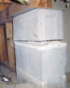 Concrete crawl space support posts in Bessemer that are showing signs of failure as they sink into the earth.