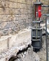 A completed installation of foundation push piers lifting a foundation in Baraga