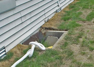 The ugly, old concrete window well of a Marquette crawl space