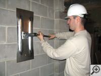 Attempting to straighten a bowed foundation wall by straightening a wall anchor system in a Iron River home.