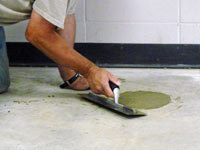 Repairing the cored holes in the concrete slab floor with fresh concrete and cleaning up the Iron River home.
