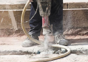 Jackhammering a slab floor in a Hancock home.