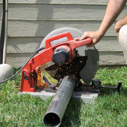 Cutting the support beam for a crawl space jack post outside a Iron River home.