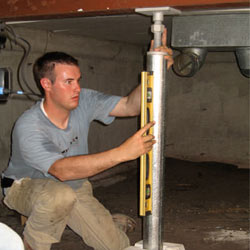 A contractor in Minocqua installing a crawl space jack post.