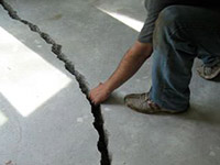 a severely damaged cracked concrete slab floor in Bessemer