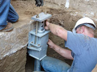 Foundation repair contractors installing the foundation bracket in Marquette.