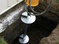 Installing a helical pier system in the earth around a foundation in Escanaba