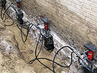 Using foundation push piers to lift a foundation during a repair in Phillips.