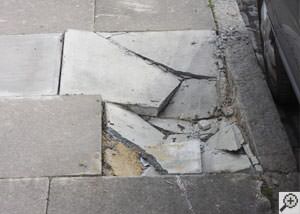 photo of a sinking concrete sidewalk with cracks in Lac Du Flambeau