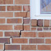 long jagged cracks starting at the corner of a window along a brick wall on a Ontonagon home