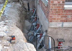 Foundation push piers installed around a house with a foundation settlement issues in Butternut