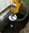 Installing a helical pier during a foundation repair in Escanaba
