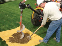 Auguring a hole in the earth for a foundation wall repair system in Iron River
