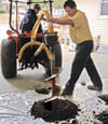Digging a hole in the garage floor to make room for a wall anchor installation in Bayfield, Michigan and Wisconsin