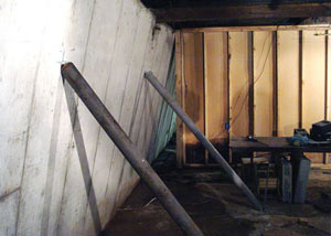 A severely tilting foundation wall propped up by steel beams in Calumet.
