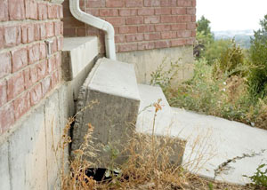 A sinking front step and cracked concrete sidewalk in Houghton.