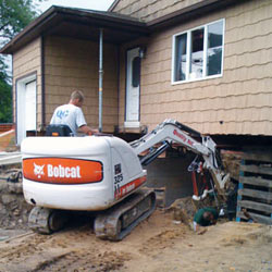 Excavating to expose the foundation walls and footings for a replacement job in Minocqua