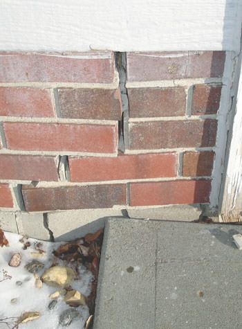Severe street creep damage to a garage wall outside a Mercer home