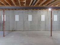 A repaired basement wall with foundation wall anchor covers installed in Hancock.