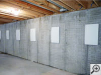 Wall anchor covers installed along a foundation wall that has been straightened in Calumet.