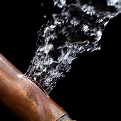 A bursting copper pipe in Escanaba, with water gushing out.