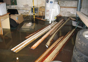 A severely flooding basement in Iron River, with lumber and personal items floating in a foot of water