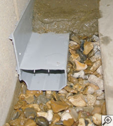 A no-clog basement french drain system installed in Hancock