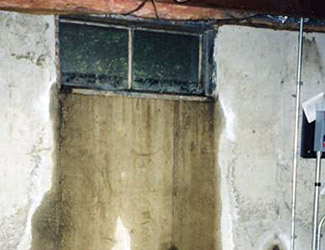 Water pouring out from a basement window in Iron Mountain